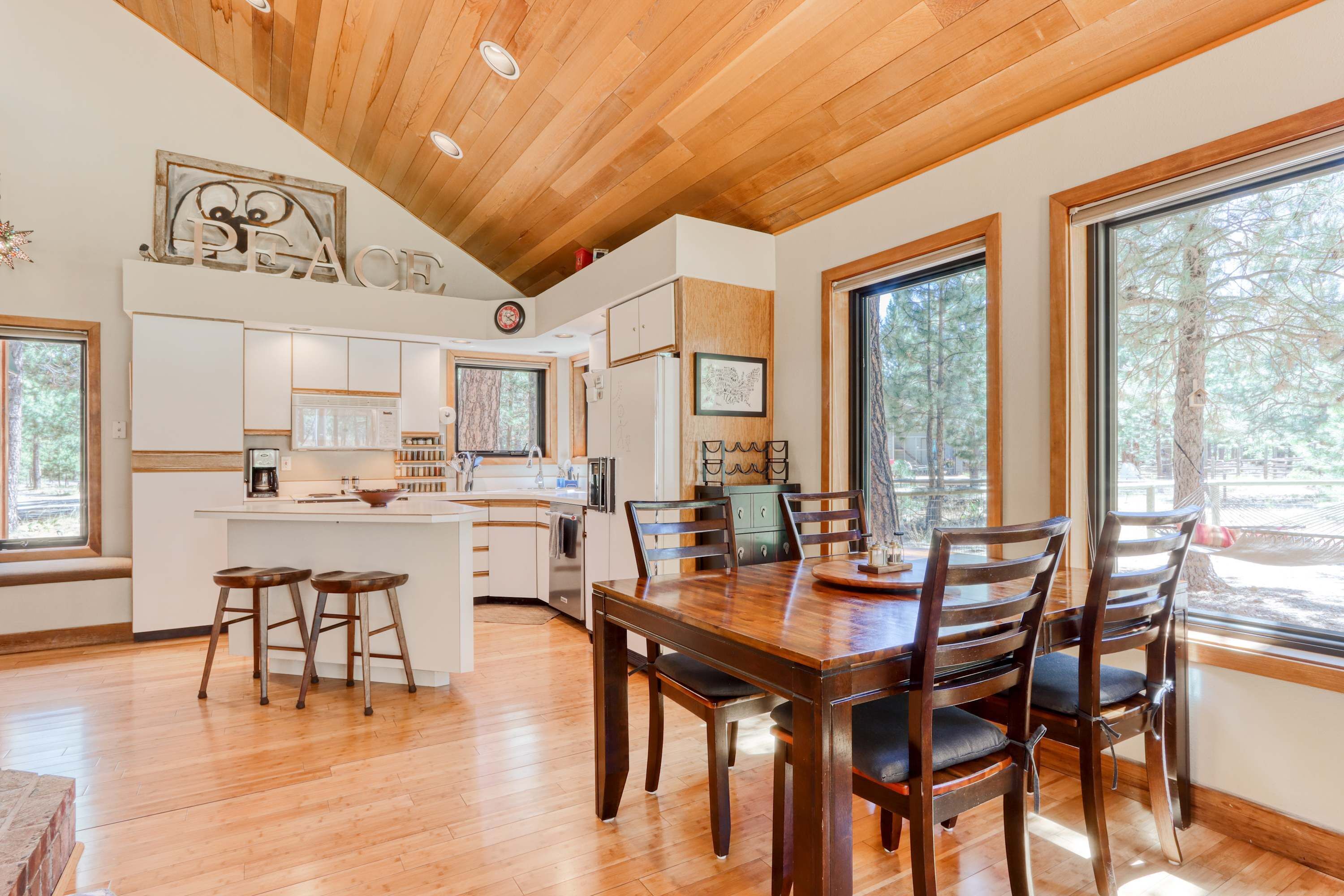A spacious kitchen with wooden cabinets, a central island, and bar stools.