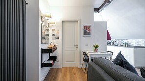 A compact living space with a kitchenette, a dining area, and a sofa. - Italianway Comfort - Baiamonti 3 A (Milan)