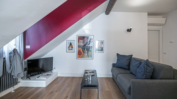 A modern living room with a TV, a sofa, a coffee table, and framed posters on the wall. - Italianway Comfort - Baiamonti 3 A (Milan)