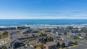 Una zona residenziale costiera con case, un parcheggio e una spiaggia sullo sfondo.