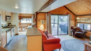 Eine moderne Küche mit Essbereich, einem roten Sofa und einem großen Fenster.