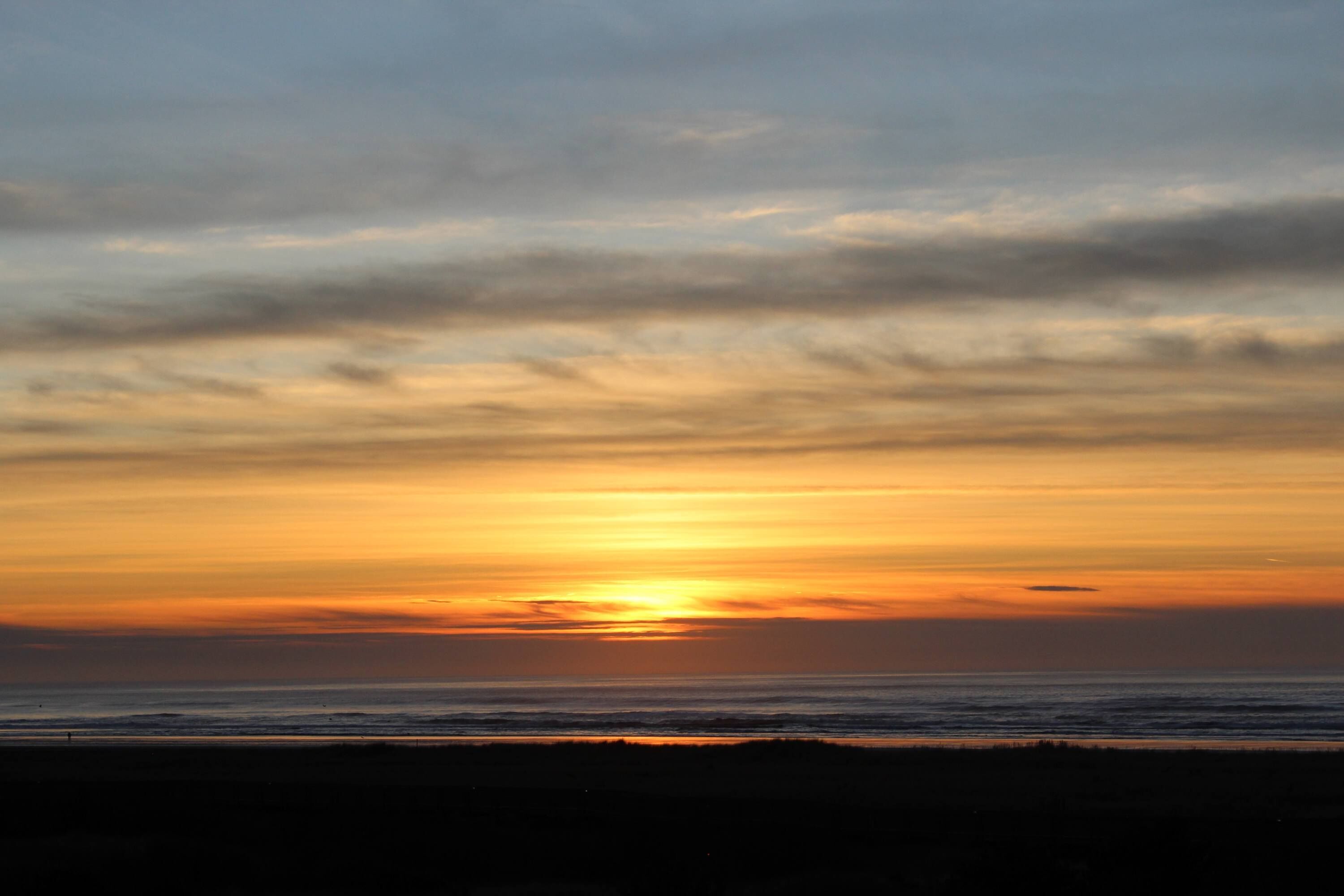 A sunset over a beach with a clear sky.
