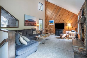 A living room with a sofa, coffee table, and fireplace.