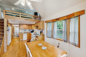 Une cuisine compacte avec une table à manger, des placards en bois et un four encastré.