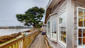 A wooden deck with a view of a body of water and a tree. - Waterfront Family Home with Beach Access - Dog-friendly (Waldport)