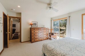 A bedroom with a large bed, a dresser, a chair, and a ceiling fan. - Sweet Sunriver Home with Private Hot Tub, Outdoor Space & Eight SHARC Passes (Sunriver)
