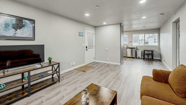 A modern living room with a flat-screen TV, wooden coffee table, and a sofa. - Spacious condo, close to the river, with WiFi, streaming, washer&dryer (Florence)