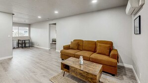 A modern living room with a sofa, a coffee table, and a small table. - Spacious condo, close to the river, with WiFi, streaming, washer&dryer (Florence)