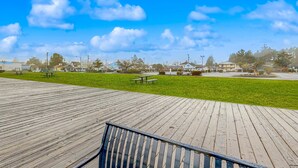 A wooden deck with picnic tables and a grassy area. - Spacious condo, close to the river, with WiFi, streaming, washer&dryer (Florence)