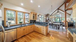 Una cocina amplia con armarios de madera, encimera de granito y un comedor con mesa y sillas.