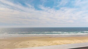 Una playa con cielo despejado y mar tranquilo.