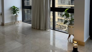 Amplia habitación con un gran ventanal, una planta en maceta y un diseño de techo moderno.