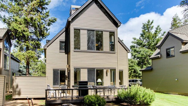 A two-story house with a deck, a patio, and a small garden. - Golf course-view townhome with private hot tub & SHARC access (Sunriver)