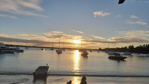 A beach with boats, a sunset, and people on the sand. - Jugroop Beach House (Tombeau Bay)