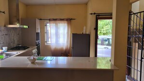 A kitchen with a sink, stove, and refrigerator. - Jugroop Beach House (Tombeau Bay)