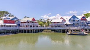 Ein Hotel am Wasser mit mehreren Gebäuden, einem Anlegesteg und einem Boot.