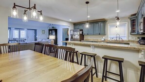 Una cocina moderna con una isla central, taburetes de bar e iluminación colgante.
