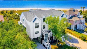 A residential area with houses, a beach, and a clear sky. - Oceanfront house with ocean views & beach access - near dining & golf (Edisto Beach)