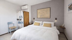 A bedroom with a large bed, a wooden chair, a map on the wall, and a small shelf with books. - Peaceful stay with spa in Andernos-les-Bains (Andernos-les-Bains)