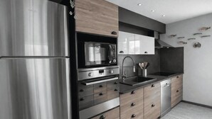 A modern kitchen with stainless steel appliances, wooden cabinetry, and a built-in microwave. - Peaceful stay with spa in Andernos-les-Bains (Andernos-les-Bains)