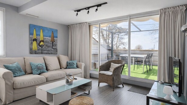 A modern living room with a sofa, coffee table, wicker chair, and a glass TV stand. - Peaceful stay with spa in Andernos-les-Bains (Andernos-les-Bains)