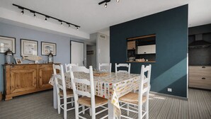 A dining area with a table set for four, surrounded by white chairs with woven seats. - Peaceful stay with spa in Andernos-les-Bains (Andernos-les-Bains)