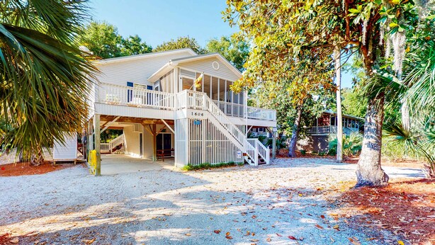 A two-story building with a covered porch and a staircase leading to the upper level. - Beautiful home within walking distance to the Beach w/ Free WiFi, Sun Deck (Edisto Beach)