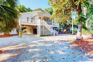 A two-story building with a covered porch and a staircase leading to the upper level. - Beautiful home within walking distance to the Beach w/ Free WiFi, Sun Deck (Edisto Beach)