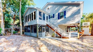 A two-story house with a covered porch, a staircase, and a fenced yard. - Beautiful home within walking distance to the Beach w/ Free WiFi, Sun Deck (Edisto Beach)
