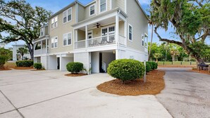 A two-story residential building with a covered front porch, a garage, and a driveway.