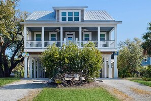 A two-story house with a porch, a sign indicating a park, and a clear sky. - Sun-Filled House Close to Beach w/Private Pool, WiFi, Central AC, & Washer/Dryer (Edisto Beach)