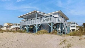 A beachfront house with a balcony, a staircase, and a view of the beach. - Beachfront home w/ Patio, Private W/D, & Free WiFi (Edisto Beach)