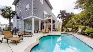 A two-story house with a swimming pool, outdoor furniture, and a covered patio area. - Fantastic House 2 Blocks From Beach w/Private Pool, Free WiFi, Central AC, & W/D (Edisto Beach)