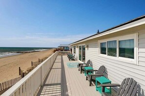 A beachfront hotel with a deck, chairs, and a view of the ocean. - Dog-Friendly Home Right On Beach w/ Private Washer/Dryer & Free WiFi (Edisto Beach)