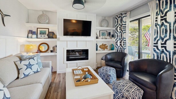 A living room with a TV, sofas, a coffee table, and patterned curtains. - Edisto condo with close proximity to beach & restaurants (Edisto Beach)