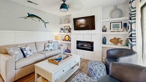 A living room with a sofa, coffee table, TV, and decorative items. - Edisto condo with close proximity to beach & restaurants (Edisto Beach)