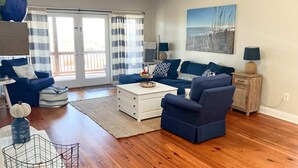 Ein Wohnzimmer mit blauem Sofa, einem weißen Couchtisch und einem Bild an der Wand.