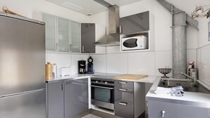 Une cuisine moderne équipée d’appareils électroménagers en acier inoxydable, d’un four à micro-ondes et d’un four encastré.