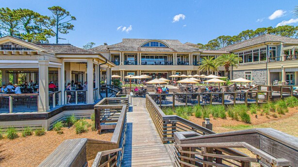 A beachfront hotel with outdoor dining, a wooden boardwalk, and multiple levels. - Bay view villa with balcony, AC, & W D  walk to beach (Hilton Head)