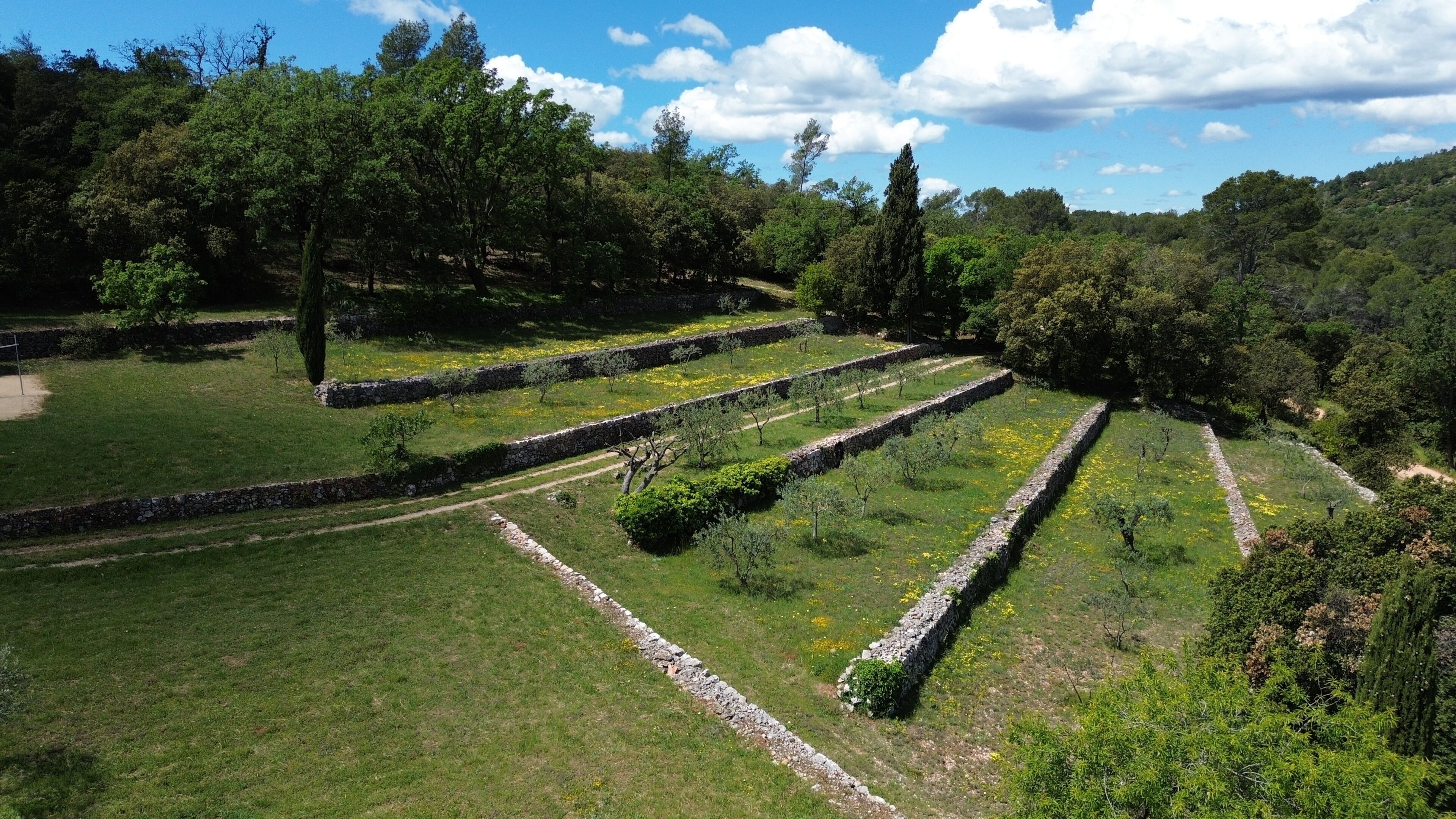 Terraced gardens with stone pathways and lush greenery.