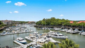 Un port de plaisance où sont amarrés des bateaux, entouré de bâtiments et de verdure.