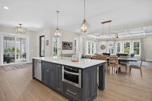 A spacious kitchen with a large island, modern appliances, and pendant lighting. - North Forest Beach home with a private pool and four primary suites (Hilton Head)