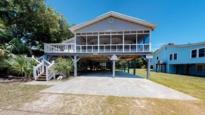 A two-story building with a balcony, a covered area, and a sign indicating a restaurant. - A Block and a Half to the Beach Dog-Friendly Home w/ Screened Porch & WiFi (Edisto Beach)