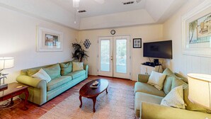 A living room with two couches, a coffee table, a TV, and a ceiling fan. - A Block and a Half to the Beach Dog-Friendly Home w/ Screened Porch & WiFi (Edisto Beach)