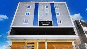 A multi-story building with a sign reading 'TOWNHOUSE' and 'Company Serviced.' - Suite Karmanghat Midtown (Hyderabad)