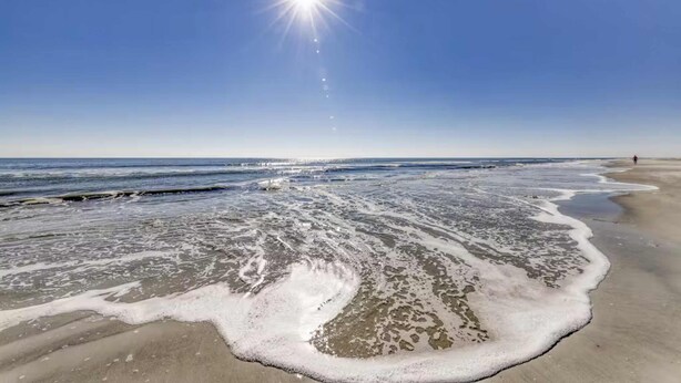 A beach with waves, a clear sky, and a bright sun. - Newly renovated villa near the beach with pool & tennis  walk to Coligny Plaza (Hilton Head)