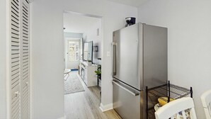 Una cocina compacta equipada con un refrigerador, un microondas y una cafetera.