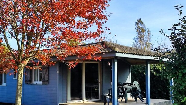 A single-story house with a porch and a covered outdoor seating area.