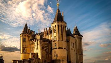 A historic castle with multiple towers and a prominent flag on top.