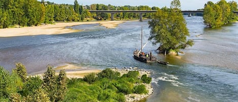 A river with boats, a bridge, and lush greenery.